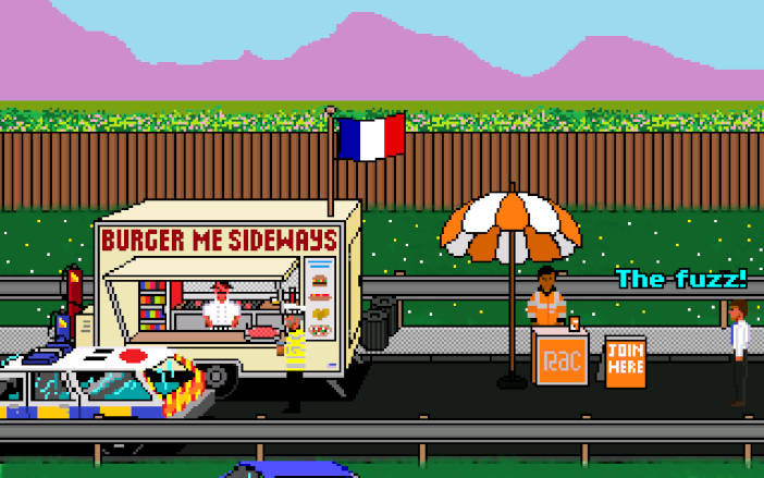 Un remolque de venta de hamburguesas en la calle del que cuelga una bandera de Francia.